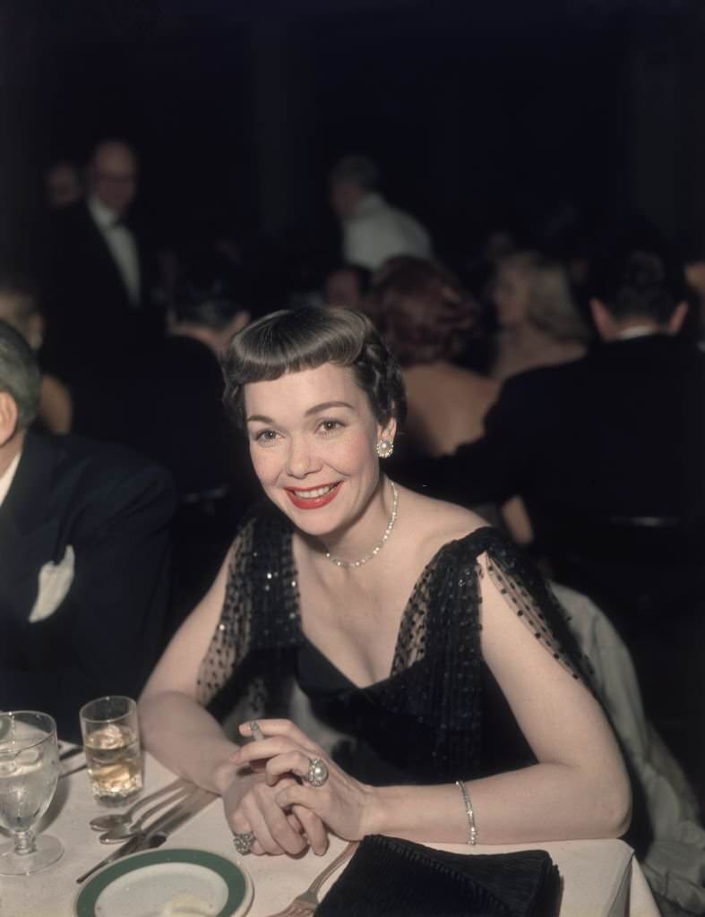 #32 American actor Jane Wyman smoking a cigarette at a formal event, dressed in black, 1950.
