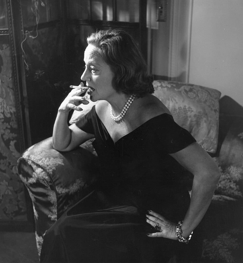 #43 American theatrical leading lady Tallulah Bankhead smoking a cigarette in London at the Ritz, 1951.