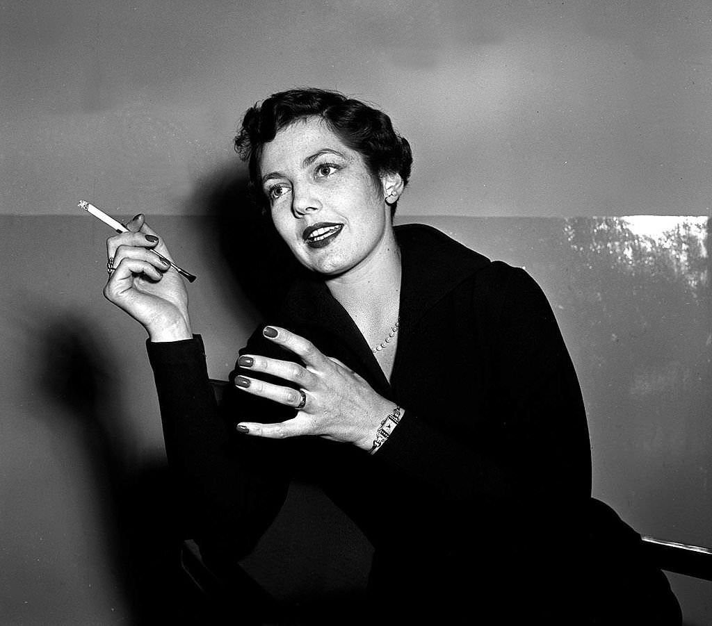 #44 Actress Diane Hart smoking a cigarette, 1952.