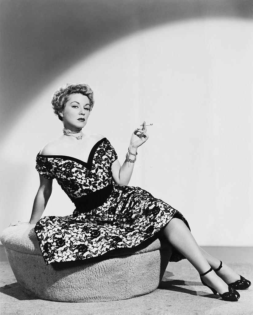 #2 Actress Claire Trevor smoking a cigarette as Connie Williams in the film “Hoodlum Empire,” 1952.