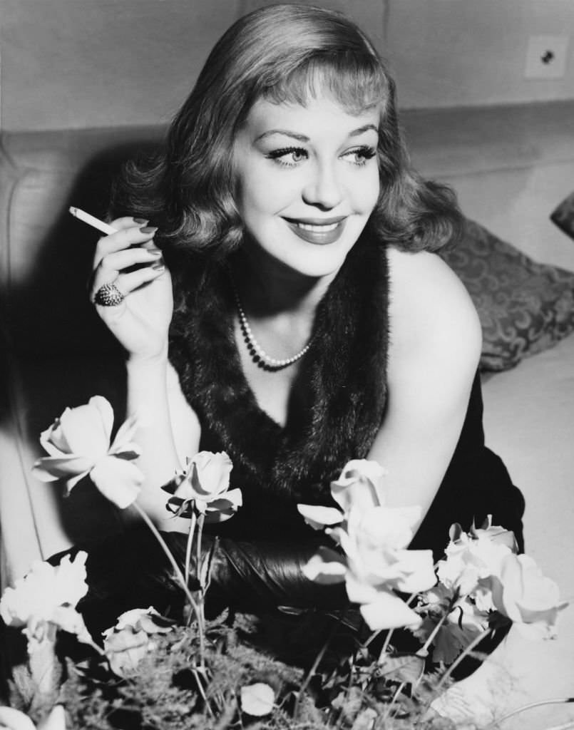 #47 German actress Hildegard Knef smoking a cigarette at her London hotel, 1952.