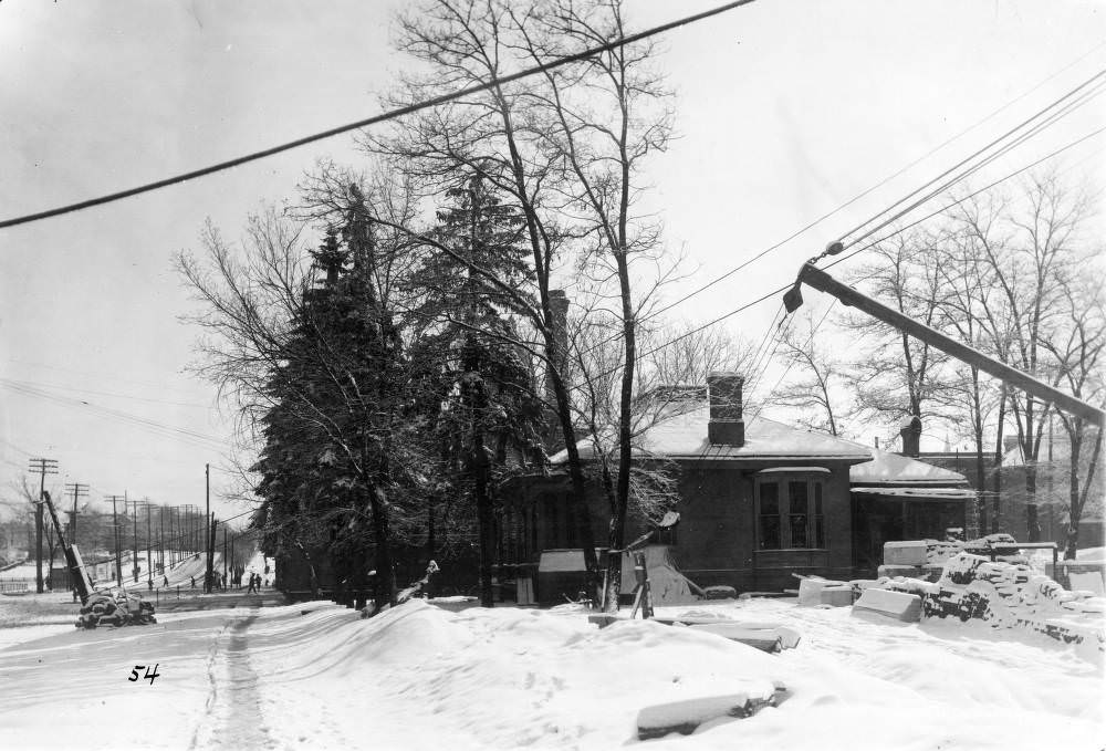 #99 Denver Public Library construction site featuring crane and snow-covered materials, Civic Center houses visible, 1900s