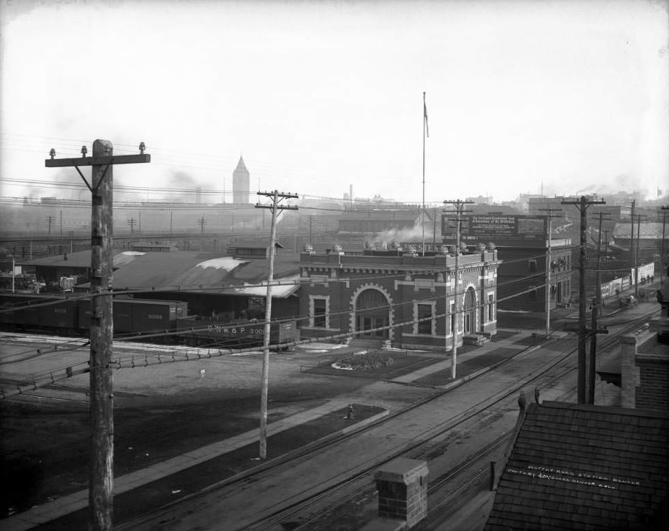#72 Moffat Road Station, featuring parked cars and billboards, 1905