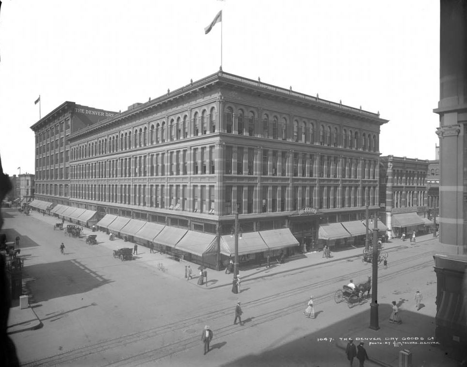 #80 Denver Dry Goods building, featuring early automobiles and various signs, 1908.