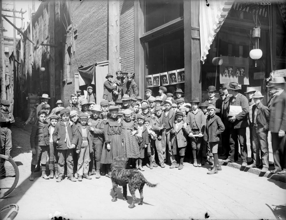 #96 Children pose outside Denver Post office, possibly delivery boys and girls, with a dog, 1900s