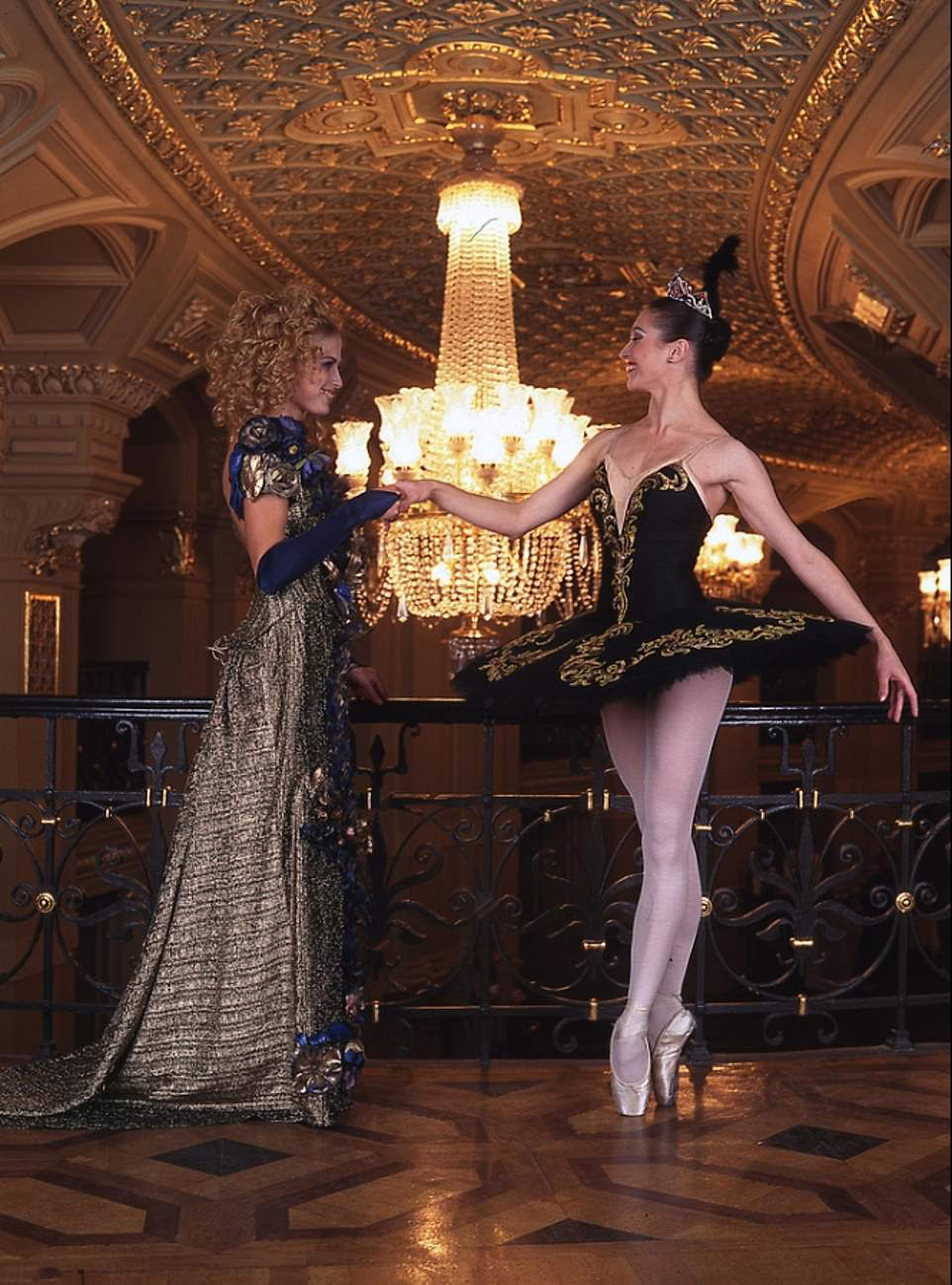 #57 Ballet Elegance: Dancer in black and gold dress holds another’s hand