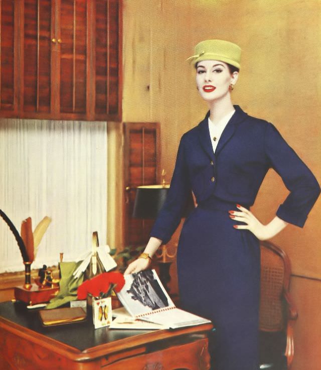 #28 Nancy Berg in a wool jersey suit with brass buttons and white pique accents, 1957.