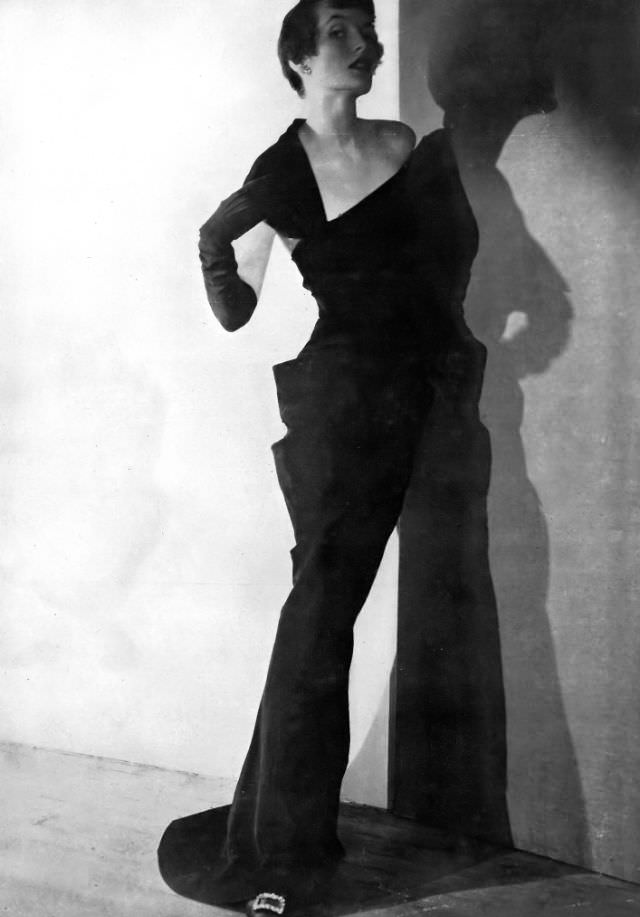#12 Maxime de la Falaise in a slim black grosgrain evening gown by Paquin, 1949.