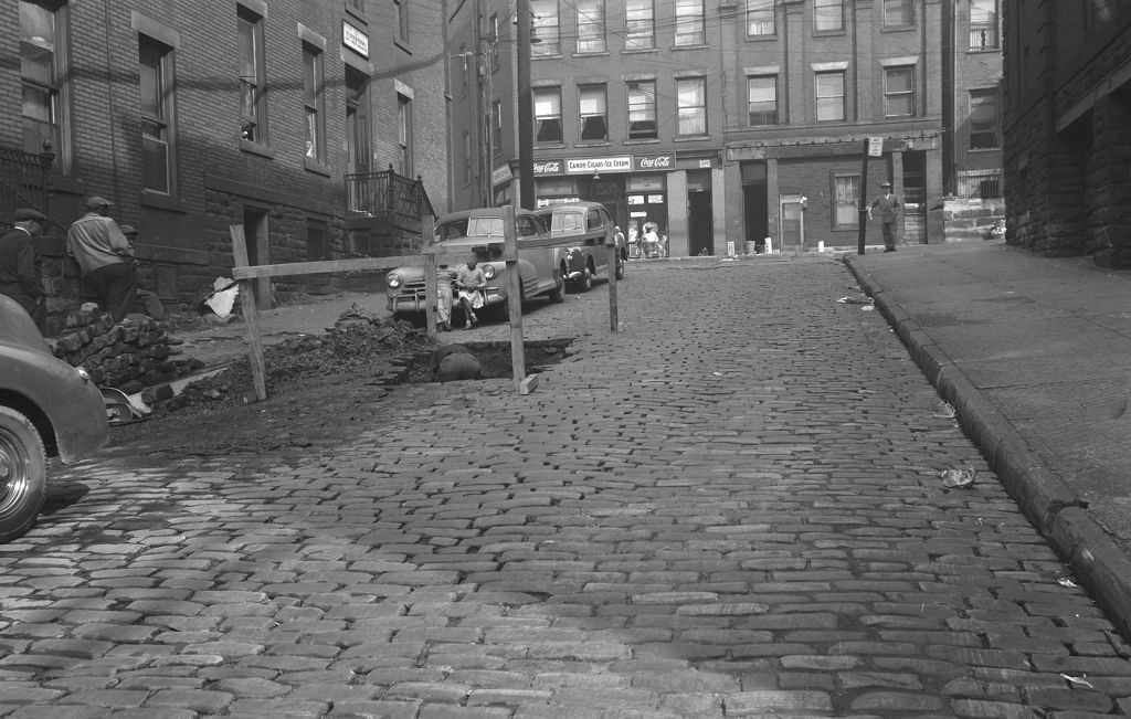 #53 Stevenson Street with workers repairing the road and children watching, 1950.