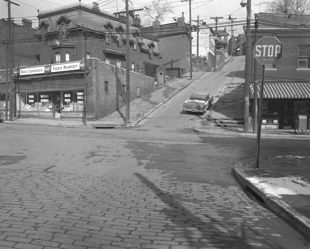 #104 Same view as above, Centre Avenue with Dave Lederstein’s Food Market and housing conditions, 1961.