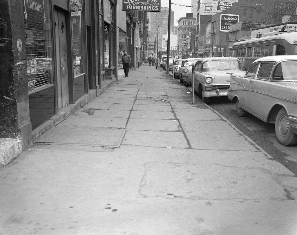 #110 Fifth Avenue downtown, features local businesses and trolley cars, 1960.