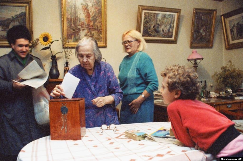 #20 Serhiy Hodorovskiy (right) watches as his grandmother, Rosa Hordorovskaiya, 80, casts her ballot in her Kyiv home. Rosa was too old to walk to the polling station, so the ballot box was brought to her.