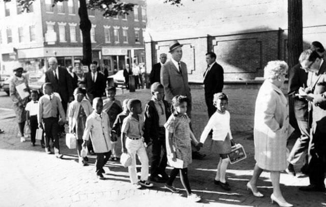 #25 Mary Lynch, an assistant principal at a school in Boston’s Roxbury community, leads first graders to a school in the city’s North End on Sept. 6, 1967. Operation Exodus, a voluntary busing program organized by Roxbury parents, transported students from overcrowded schools in predominantly black neighborhoods to schools in predominantly white neighborhoods that had vacant seats