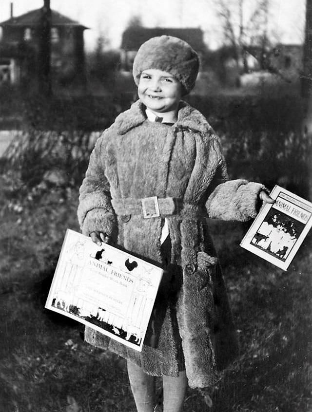 #4 A 5-year-old girl shows off her books after her first day of kindergarten, circa 1929