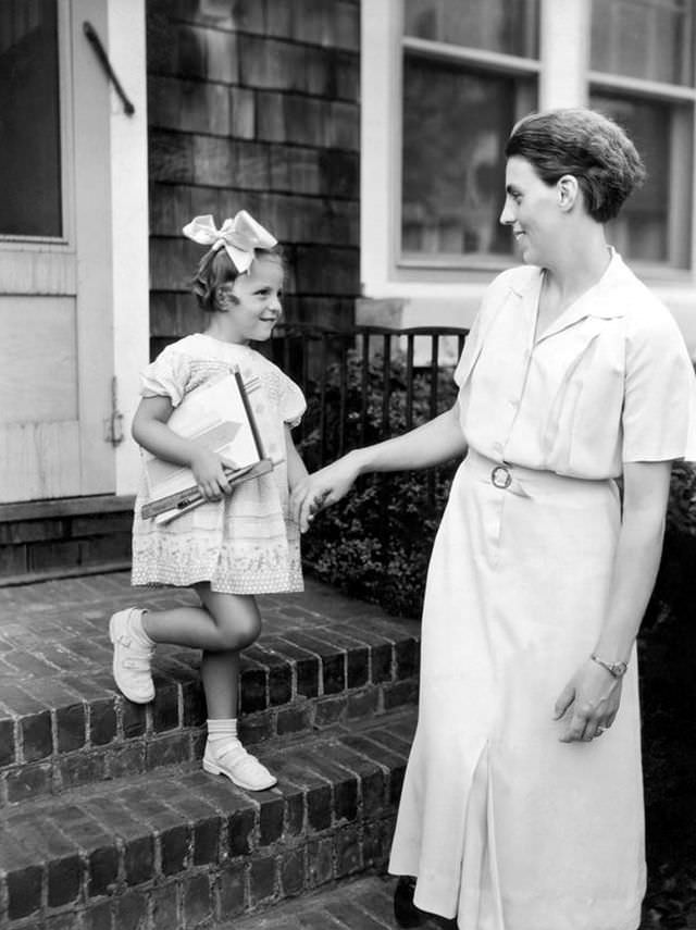 #5 A mother takes her daughter by the hand as they head to school in the late 1920s or early 1930s