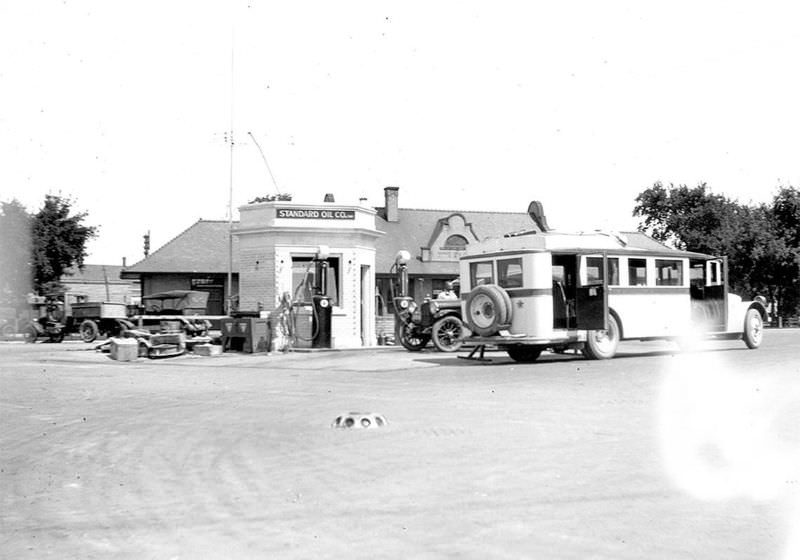 #84 Smallest gas station next to the bus stop in downtown Detroit Lakes, 1930s.
