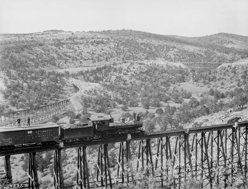 #6 Freight train on a high trestle, two men on car roof, 1895.