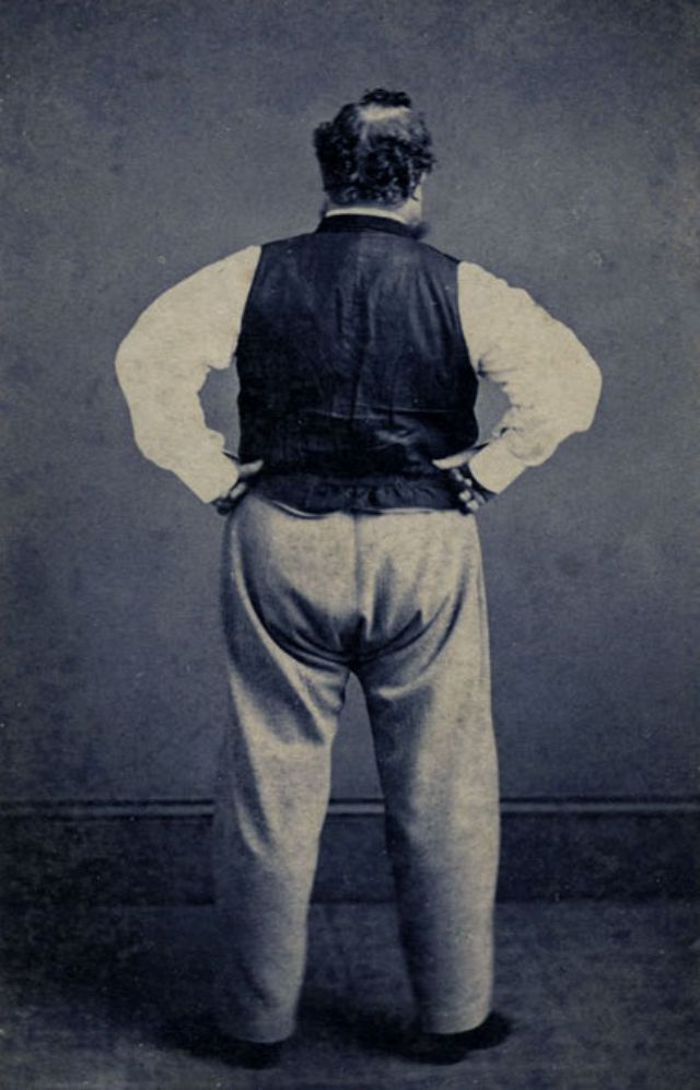 #21 Back view of a balding man with hands placed on his hips