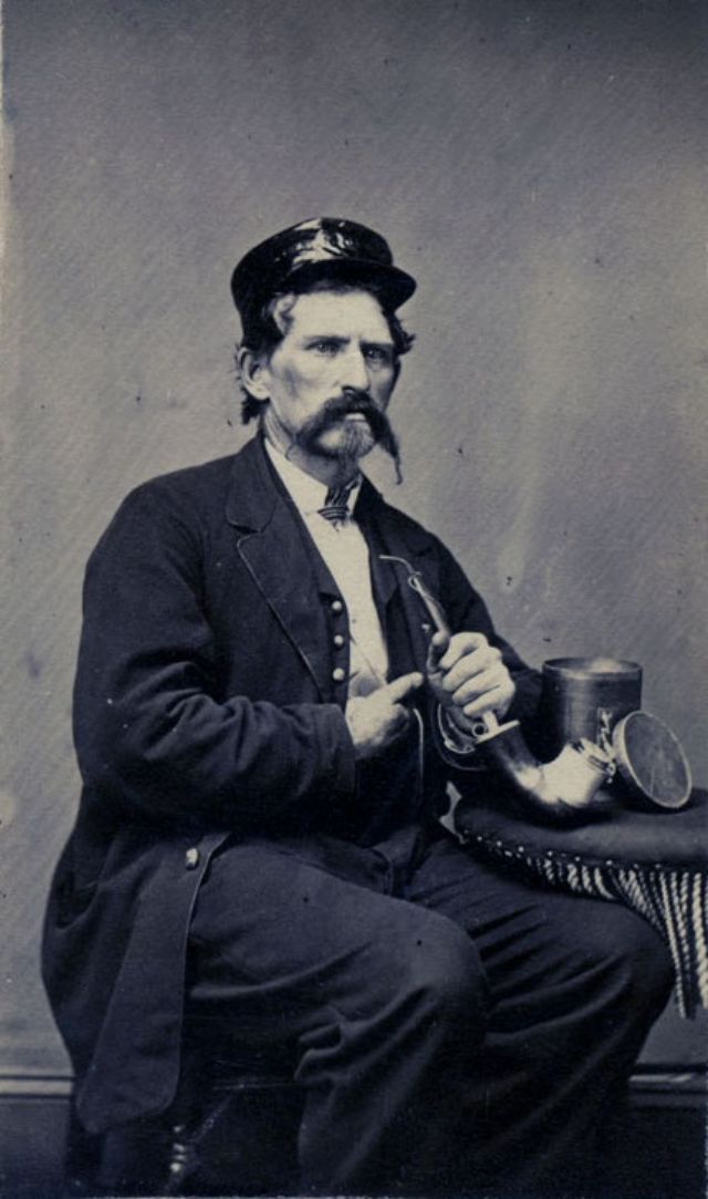 #3 A gentleman poses with his pipe and a humidor