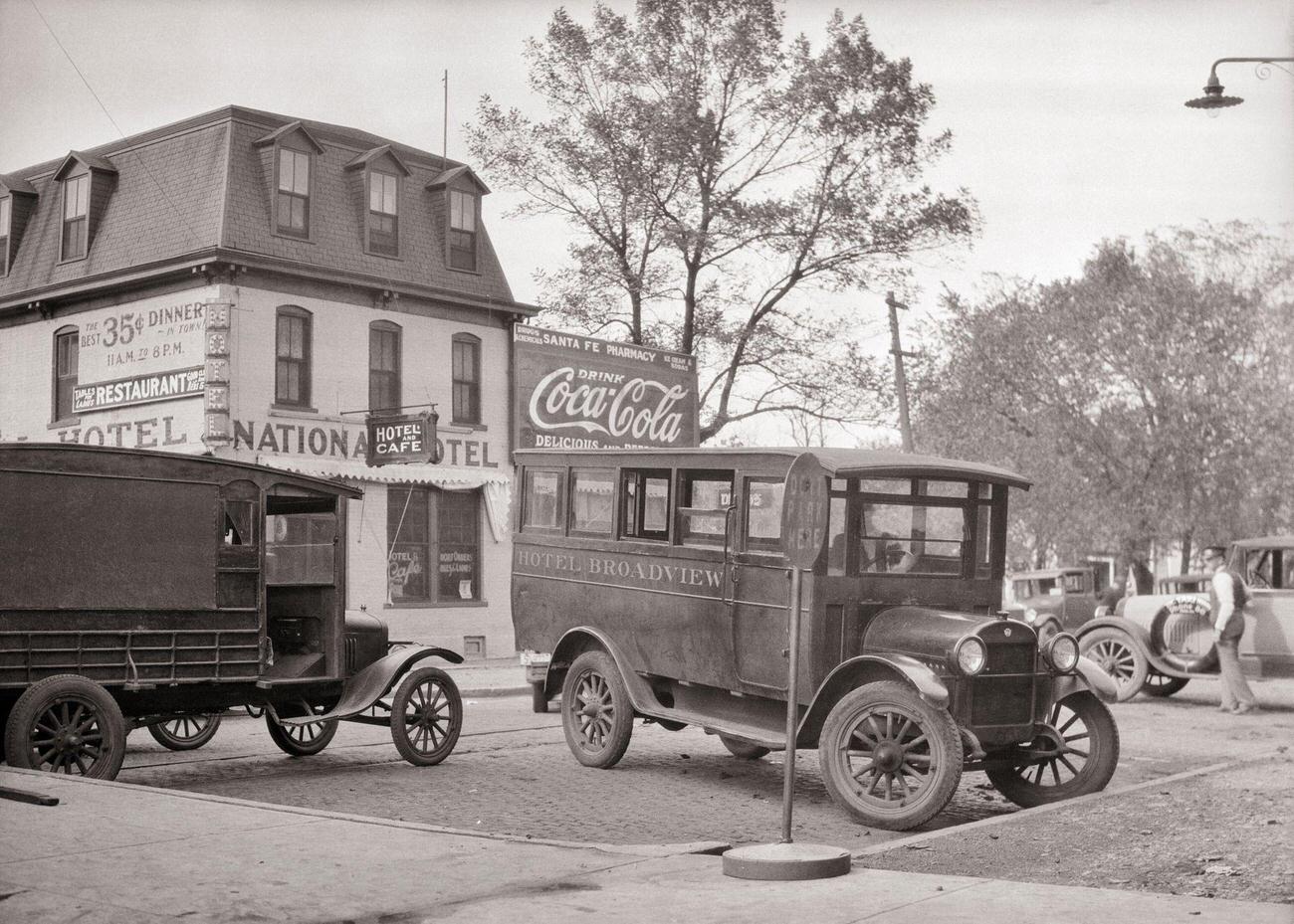 #10 A 1920s motor bus and delivery van parked at a railway station in Emporia, Kansas, USA.