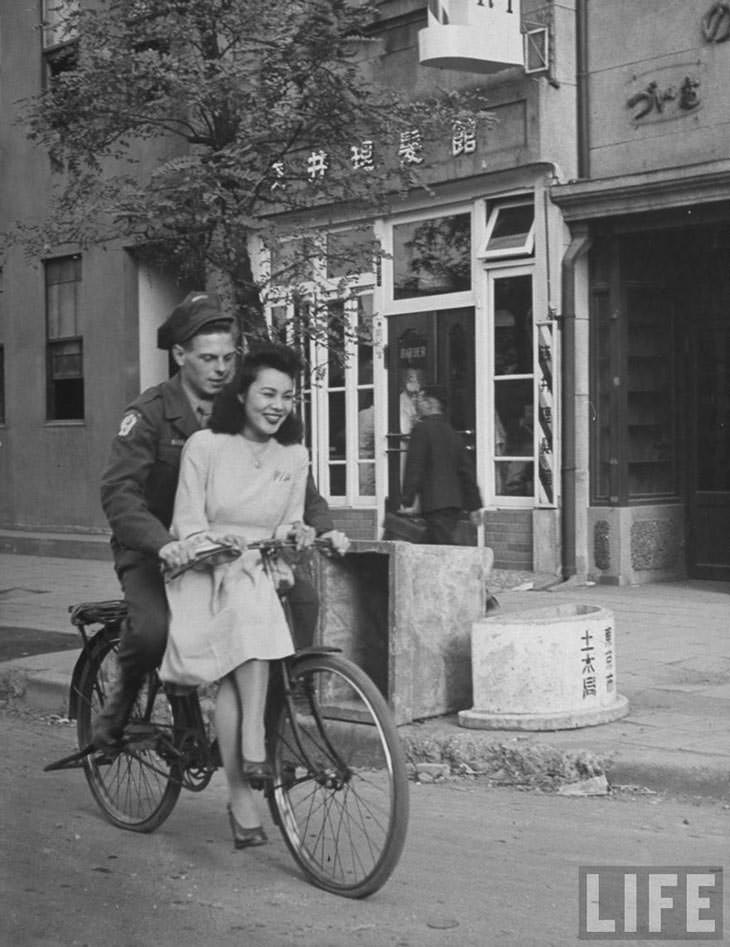 #21 US soldier giving Japanese girl bicycle ride, Japan, 1946.