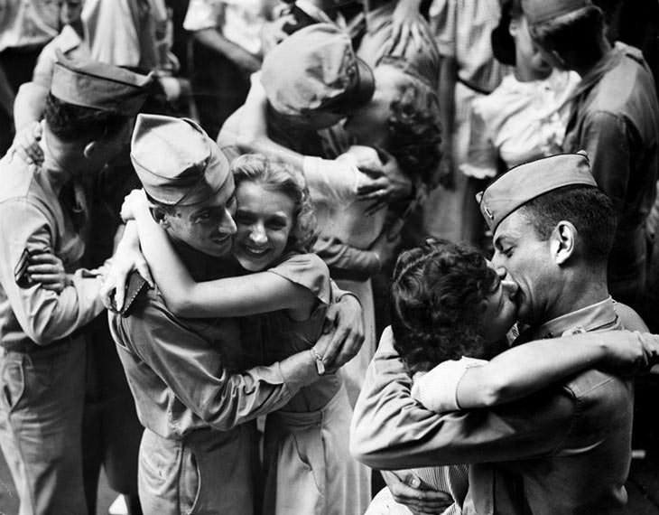 #26 Servicemen and workers embrace and kiss, 1945.