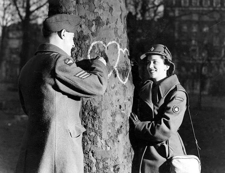 #29 Young couple chalking hearts on tree, Valentine’s Day, 1944.