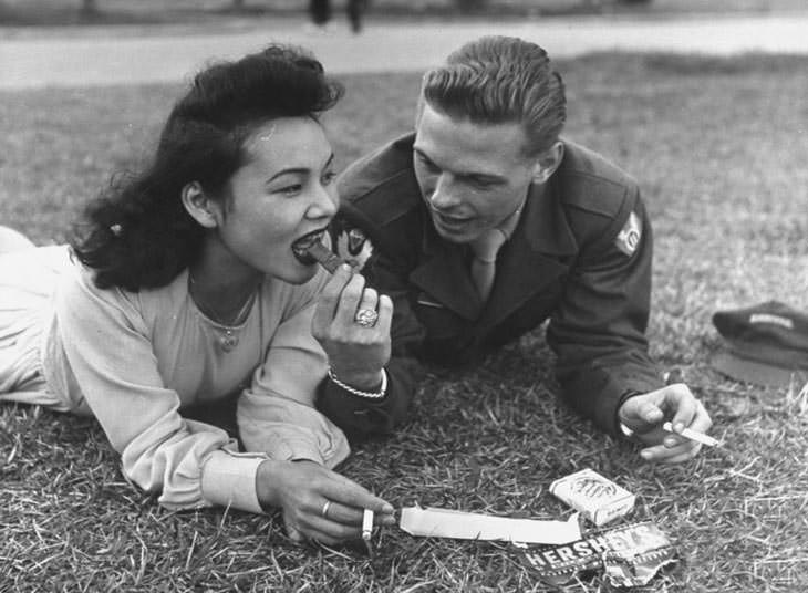 #30 US soldier sharing chocolate bar and cigarettes, 1940s.