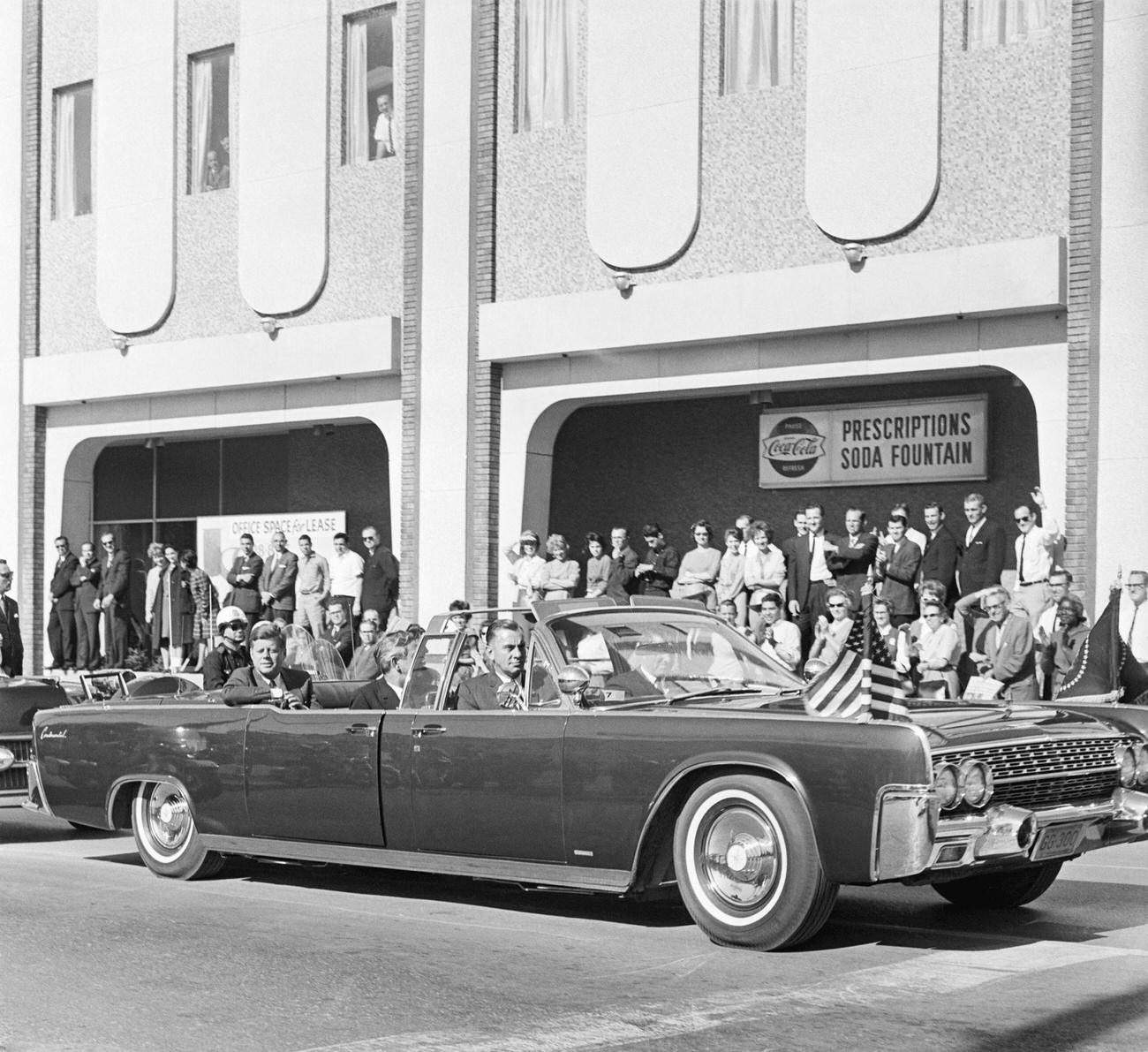 #4 John F. Kennedy and Texas Governor John Connally ride in a convertible in Dallas, moments before the assassination, 1963.