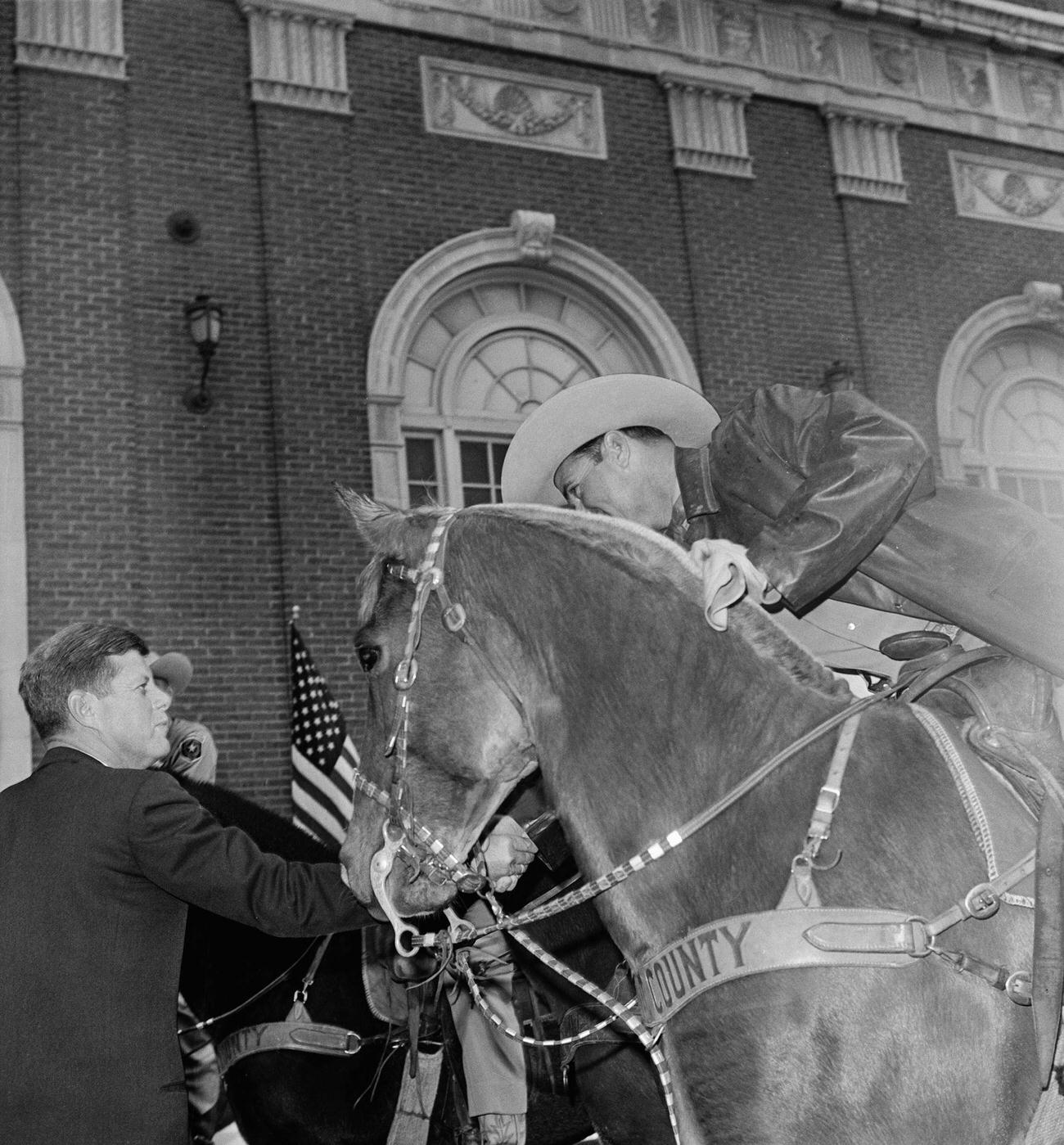 #7 John F. Kennedy shakes hands with a mounted Tarrant County Sheriff’s posse member after an outdoor speech, hours before his assassination in Dallas, 1963.