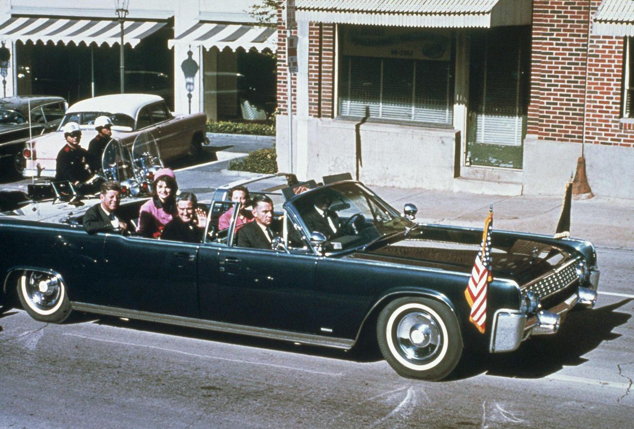 #9 John F. Kennedy, First Lady Jacqueline Kennedy, Texas Governor John Connally, and his wife Nellie ride together in a Dallas limousine, 1963.