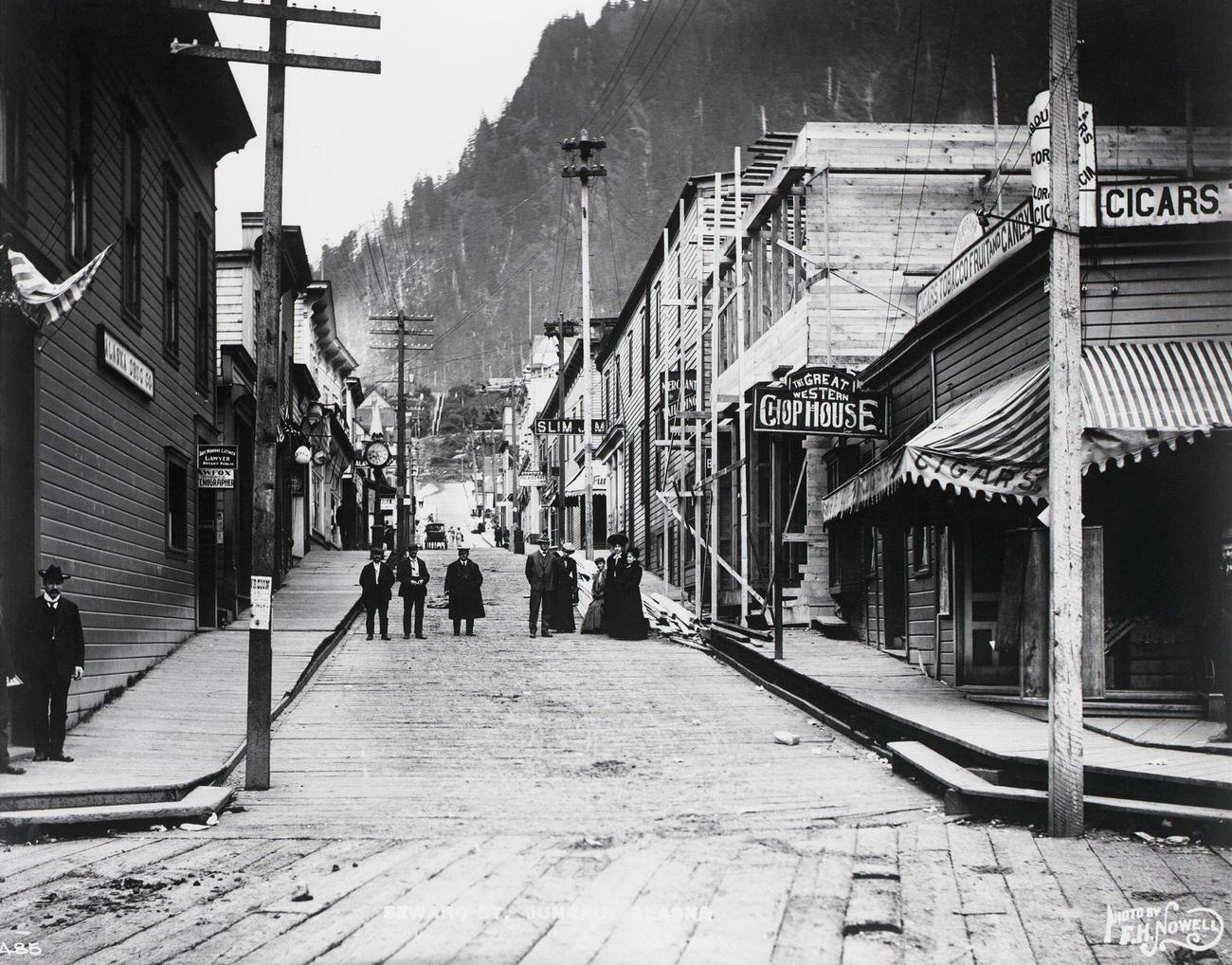 #7 People gathered on Seward Street in a boom town during the Klondike Gold Rush, Alaska.