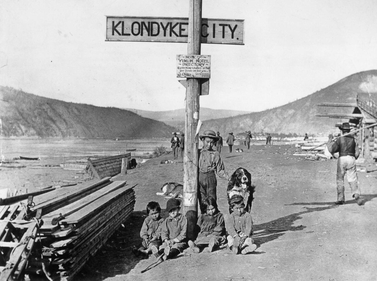 #112 Children with their dog by a street sign in the Klondike area, Yukon Territory, Canada, 1890.