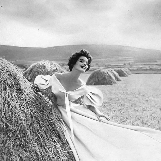 #5 Linda Harper in a fog-gray faille dinner dress with pleated pillow sleeves by Sybil Connolly, Ireland, 1953.