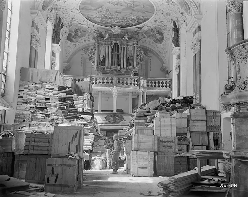 #2 American soldier inspecting German loot, Elligen, Germany.