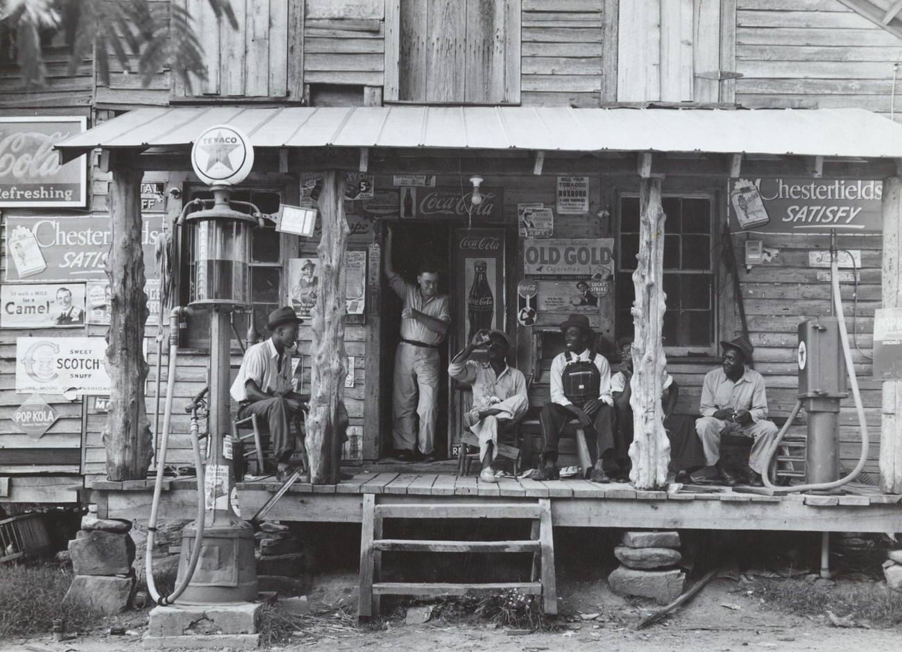 #4 African American and a white store owner on the porch of a country store, circa 1939.