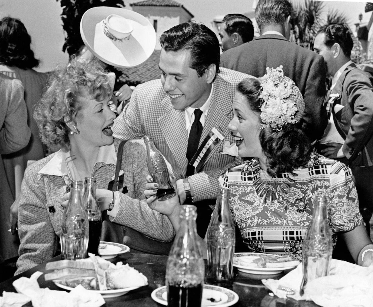 #7 Married actors Lucille Ball and Desi Arnaz drinking Coca-Cola with actress Jinx Falkenburg, 1942.