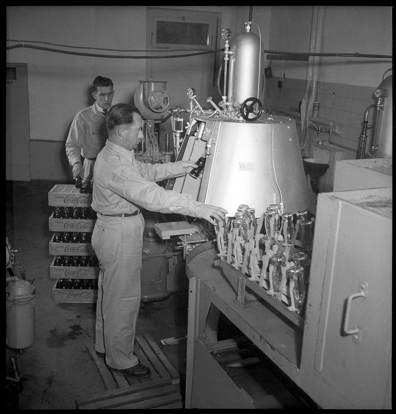 #51 Coca-Cola worker at a bottling plant with a bottle, 1949.