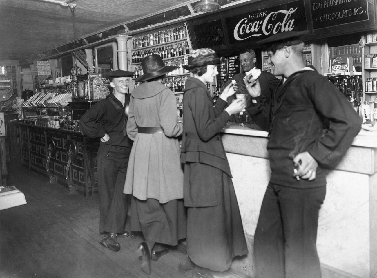 #1 Two sailors and their dates drinking Coca-Cola at a soda fountain, World War I era.