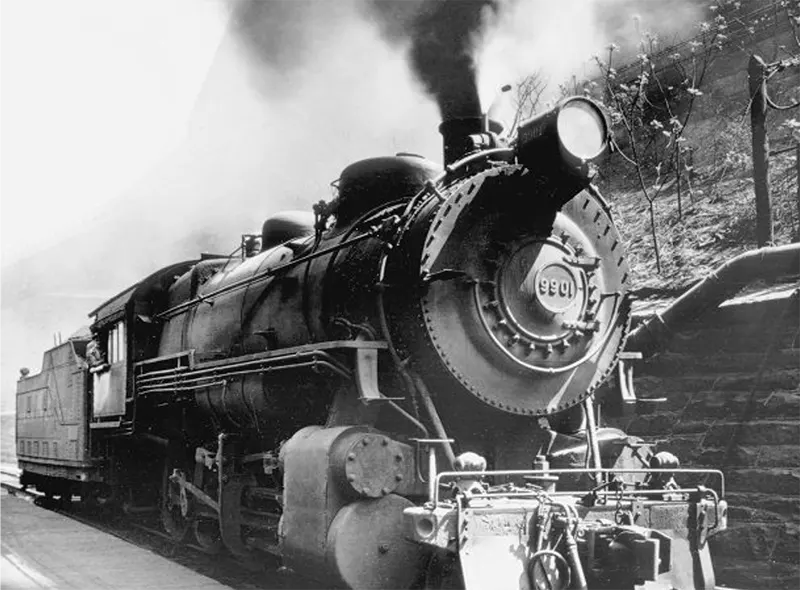 #1 Steam locomotive #9901 expelling smoke at a railway station.