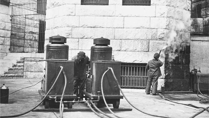 #17 Man cleaning Allegheny County Courthouse exterior, another smoking near a cleaning machine.