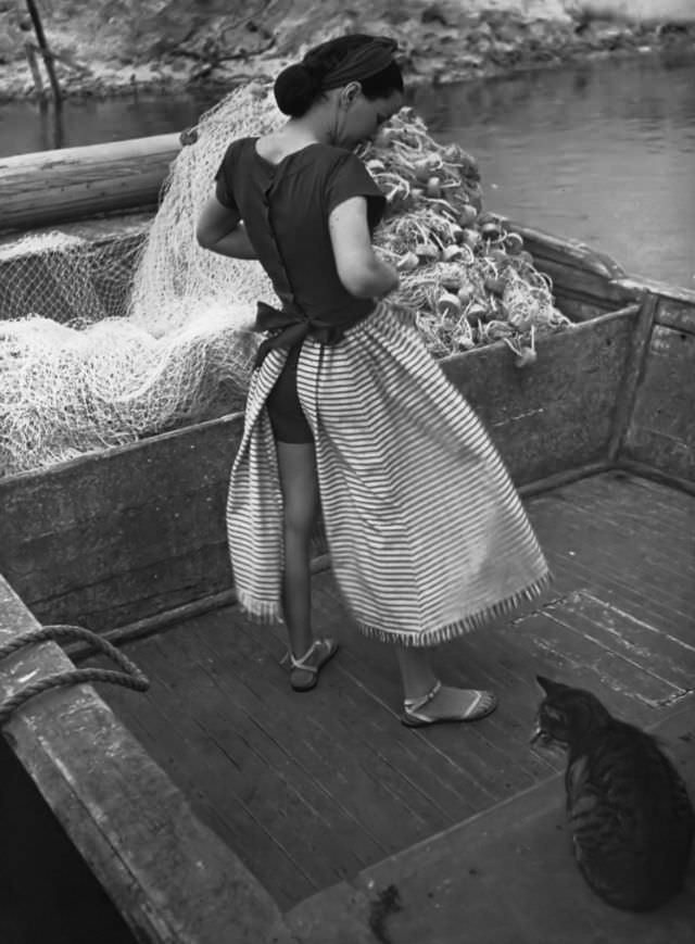 #16 Model sports a blue-and-white striped Guatemalan cotton beach apron over a blue jersey sunsuit by Tina Leser, 1947.