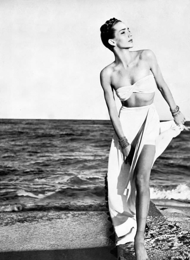 #5 A model in a stone-white rayon-jersey two-piece swimsuit with a long evening skirt and Lampl jewelry, Harper’s Bazaar, 1945.