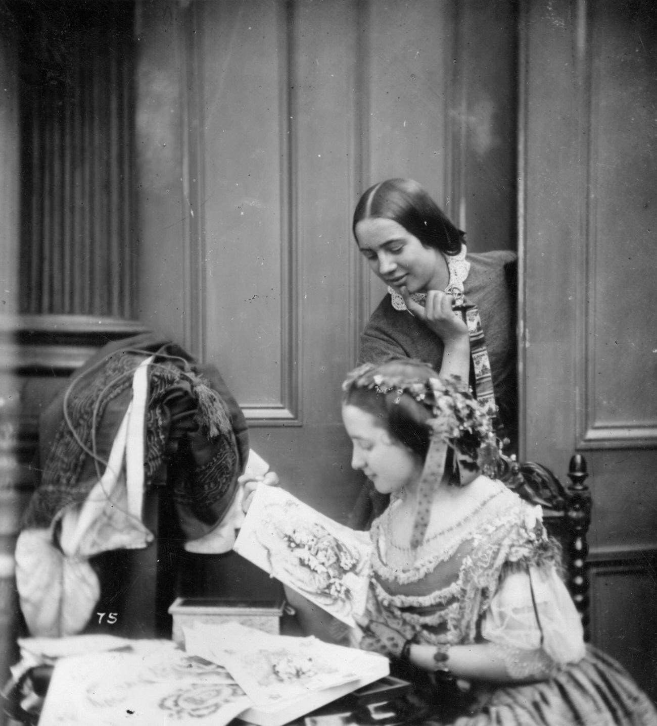 #95 Two Victorian women admiring Valentine cards, circa 1860.