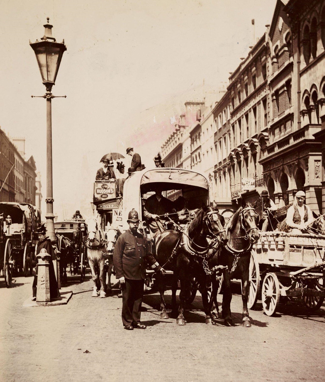 #65 Policeman directing horse-drawn traffic in London, circa 1900.