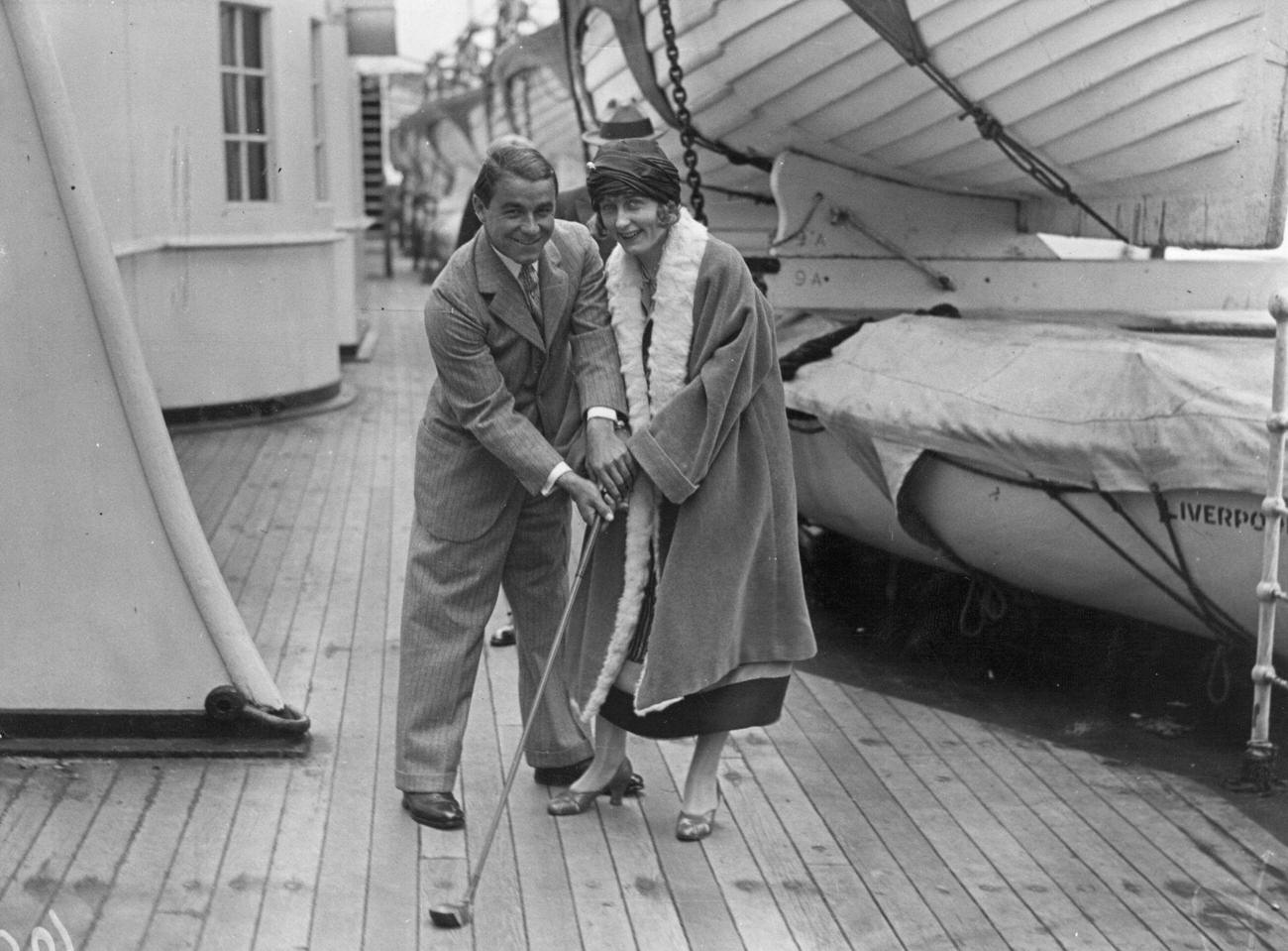 Gene Sarazen helping his wife practice golf, “Mauretania”, June 1, 1924.