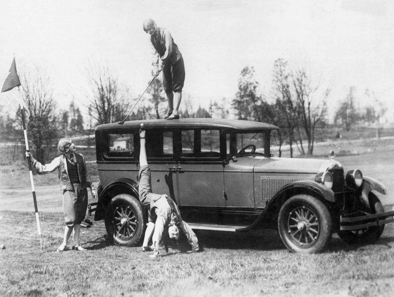 Woman hitting golf ball off another woman’s foot, 1927.