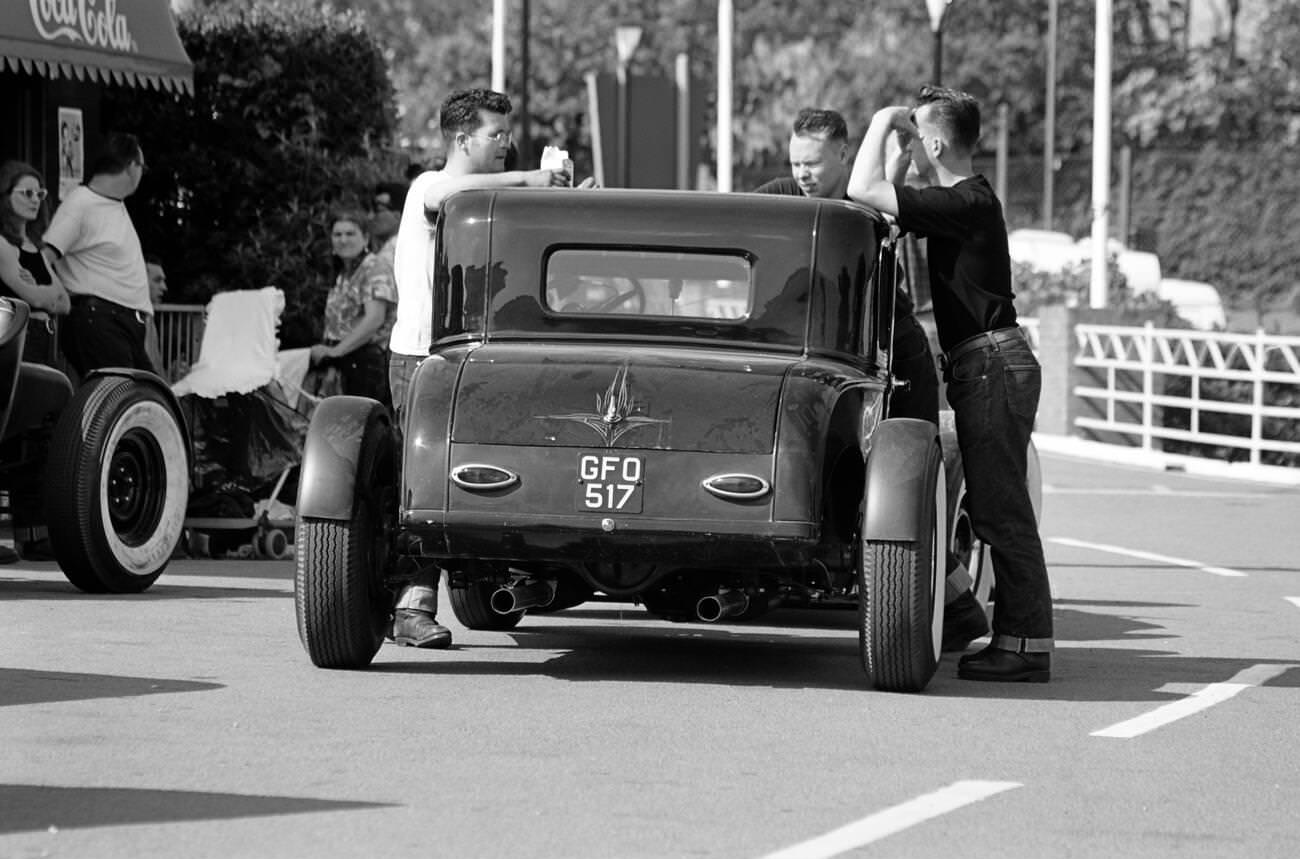 #16 “Greasers” by their 1950s street rod at a rock ‘n’ roll retro festival.