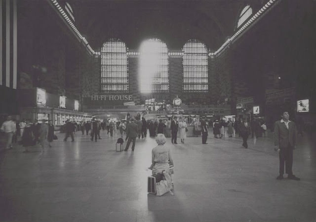 #27 Woman sitting on luggage in Grand Central Terminal, September 1958