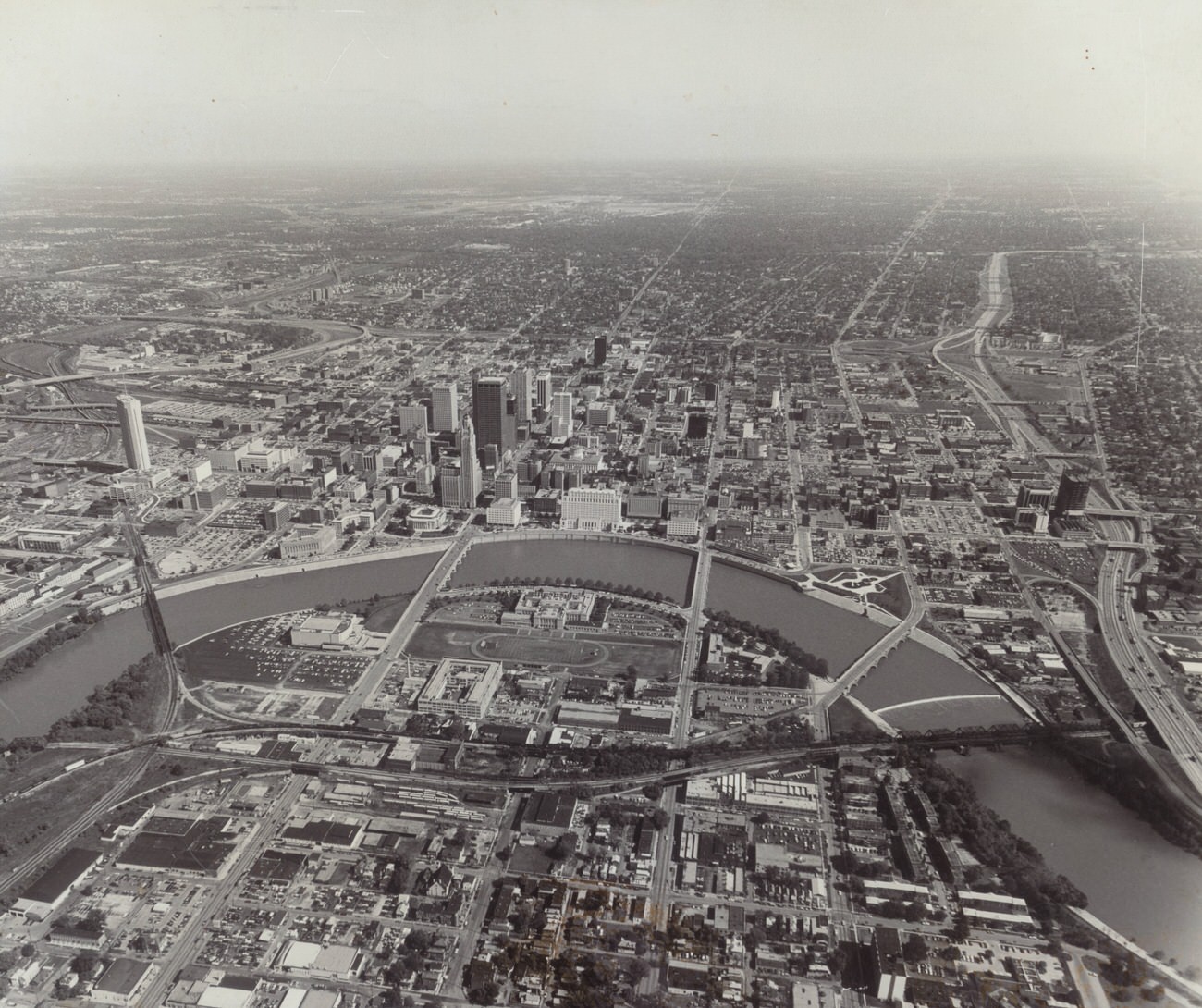#12 Aerial view of the Scioto River and downtown Columbus, featuring Nationwide building and Franklin County Jail, 1970s
